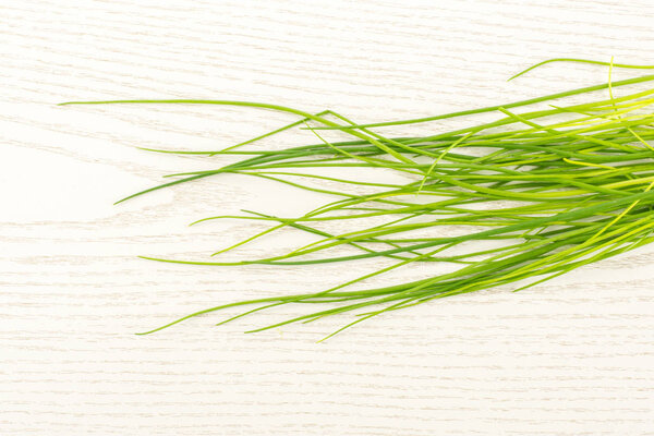 Fresh chives table top isolated on grey wood background grass-like leave