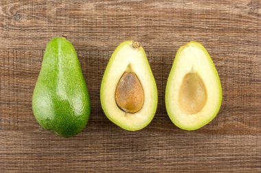 Yeşil yumuşak avokado koleksiyonu masa üstü izole kahverengi ahşap zemin pastırma çeşitli bir bütün iki bölüm yarım görmek