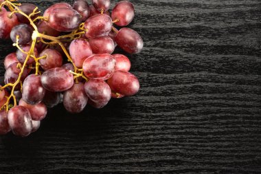 Siyah ahşap arka plan koyu pembe berrie izole kırmızı küre üzüm küme masa üstü