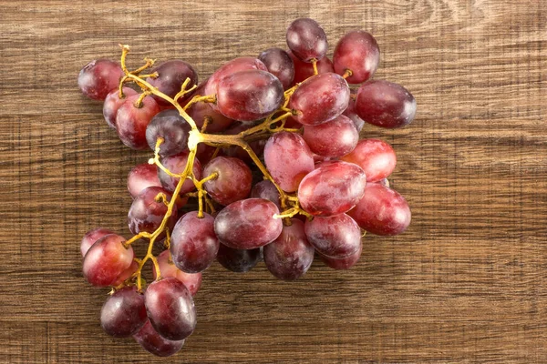 Red globe grape rich cluster table top isolated on brown wood background dark pink berrie