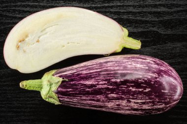 Çizgili mor patlıcan koleksiyonu üstten görünüm siyah ahşap arka plan üzerine bir bütün izole ve bölüm hal dilimlenmiş