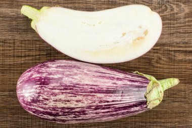 Çizgili mor patlıcan koleksiyonu üstten görünüm kahverengi ahşap arka plan üzerinde bir bütün izole ve bölüm hal dilimlenmiş