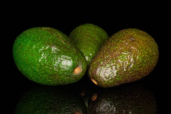 Frische grüne Avocado isoliert auf schwarzem Glas — Stockfoto