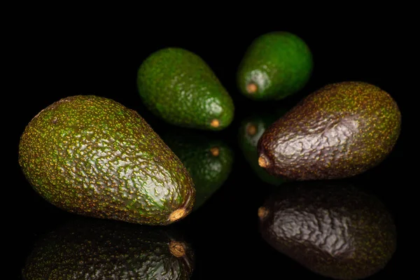 Frische grüne Avocado isoliert auf schwarzem Glas — Stockfoto