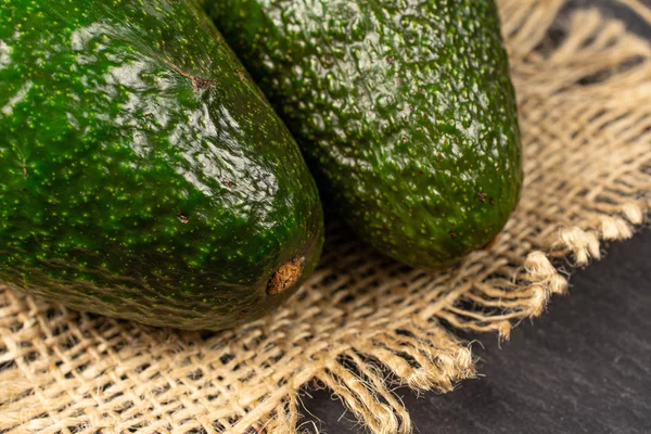 Frische grüne Avocado auf grauem Stein — Stockfoto