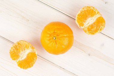 Gri ahşap üzerinde taze turuncu mandalina