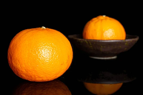 Fresh orange mandarine isolated on black glass — Stock Photo, Image