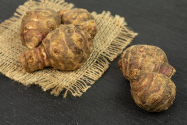 Gri taşta taze kahverengi Kudüs enginarı