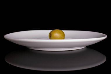 Yeşil çukur zeytin meyvesi siyah camda izole edilmiş.