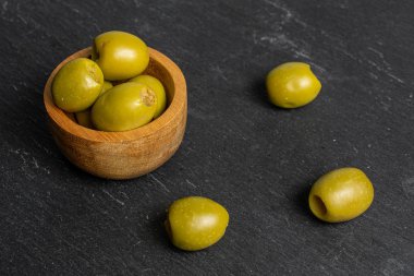 Gri taşın üzerinde yeşil zeytin meyvesi