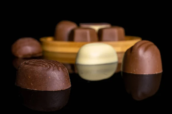 Bonbons pralinés au chocolat isolés sur verre noir — Photo