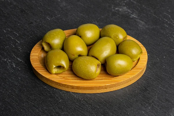 Grön urkärnad olivfrukt på grå sten — Stockfoto