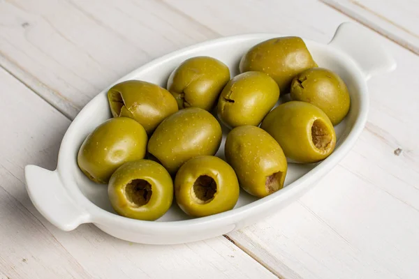 Olive verdi snocciolate su legno grigio — Foto Stock