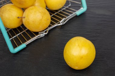 Gri taşın üzerinde taze sarı erik