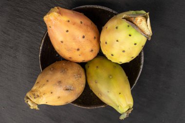 Gri taşın üzerinde yeşil dikenli armut