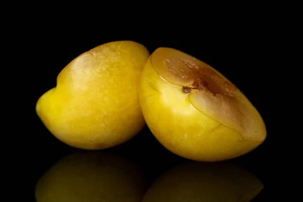 Frische gelbe Pflaume isoliert auf schwarzem Glas — Stockfoto