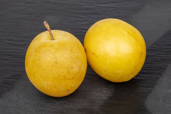 Frische gelbe Pflaume auf grauem Stein — Stockfoto