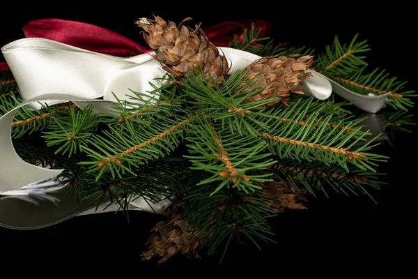 Rama de árbol de Navidad aislada en vidrio negro —  Fotos de Stock