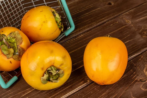Söt apelsin persimon på brunt trä — Stockfoto