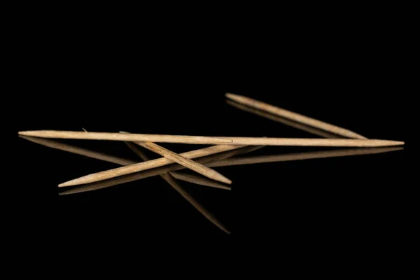 Wooden brown toothpick isolated on black glass — Stock Photo, Image