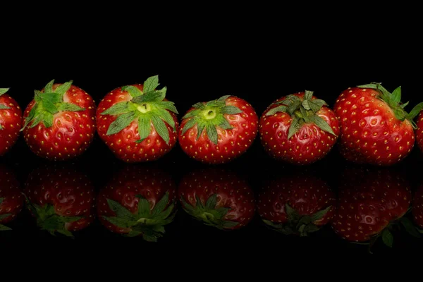 Fresh red strawberry isolated on black glass — Stock Photo, Image