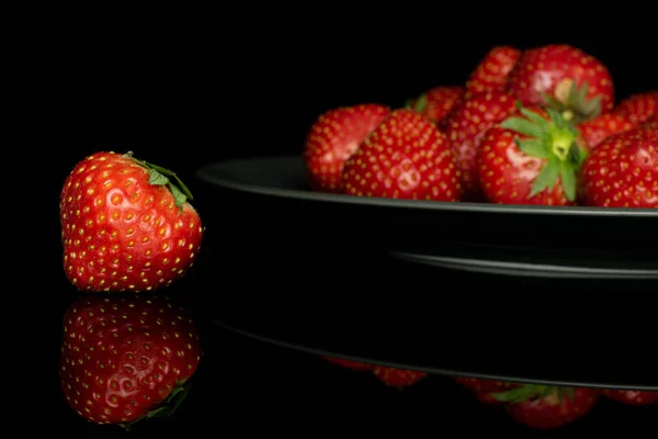 Fresh red strawberry isolated on black glass — Stock Photo, Image