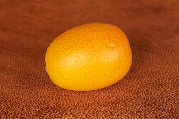 Savoureux kumquat orange sur cuir cognac — Photo