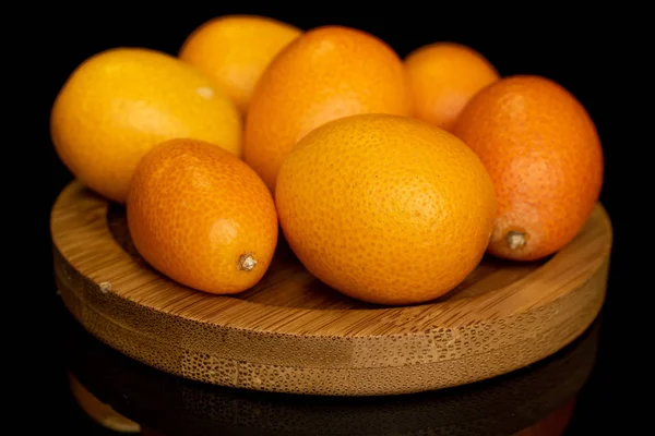 Schmackhafter Orangenkumquat isoliert auf schwarzem Glas — Stockfoto