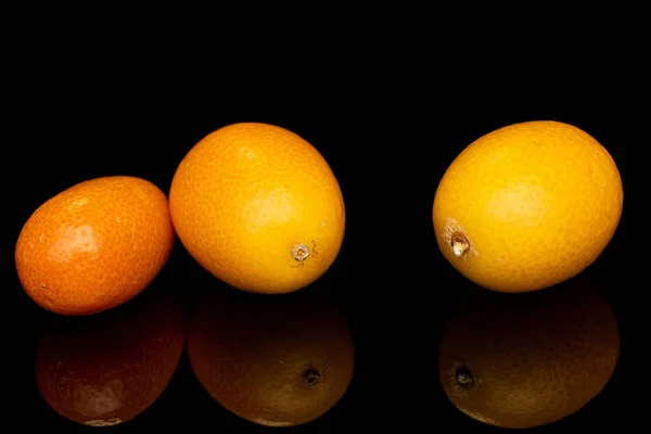 Tasty orange kumquat isolated on black glass — Stock Photo, Image