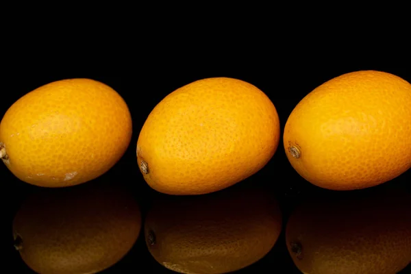 Kumquat laranja saboroso isolado em vidro preto — Fotografia de Stock