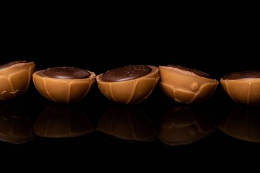 Tatlı kahverengi şeker, siyah camda izole edilmiş.