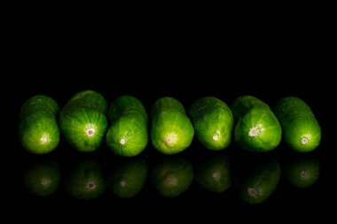 Siyah camda izole edilmiş taze yeşil bebek salatalığı.