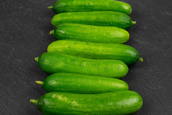 Pepino de bebê verde fresco em pedra cinza — Fotografia de Stock