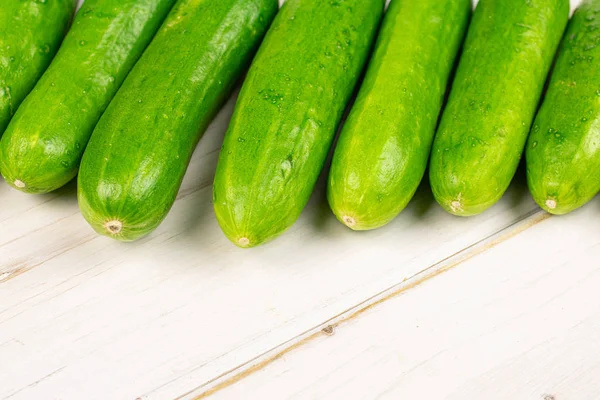 Verse groene babykomkommer op grijs hout — Stockfoto