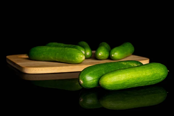 Pepino de bebê verde fresco isolado em vidro preto — Fotografia de Stock