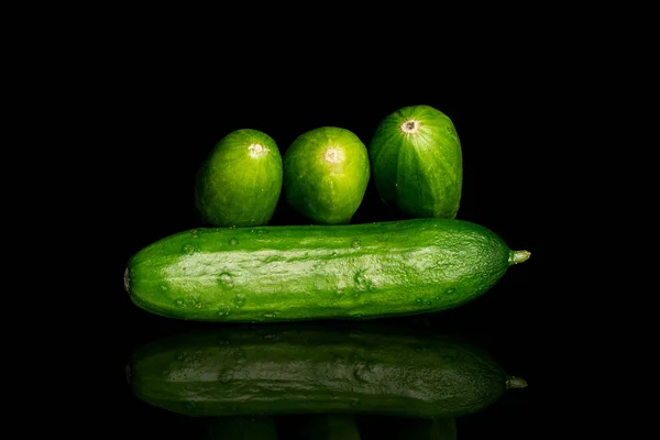 Čerstvé zelené okurky izolované na černém skle — Stock fotografie