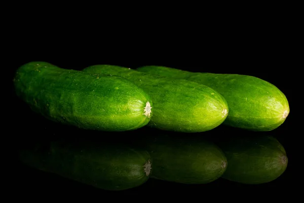 Frische grüne Babygurke isoliert auf schwarzem Glas — Stockfoto