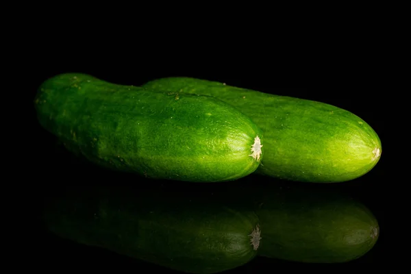 Frische grüne Babygurke isoliert auf schwarzem Glas — Stockfoto