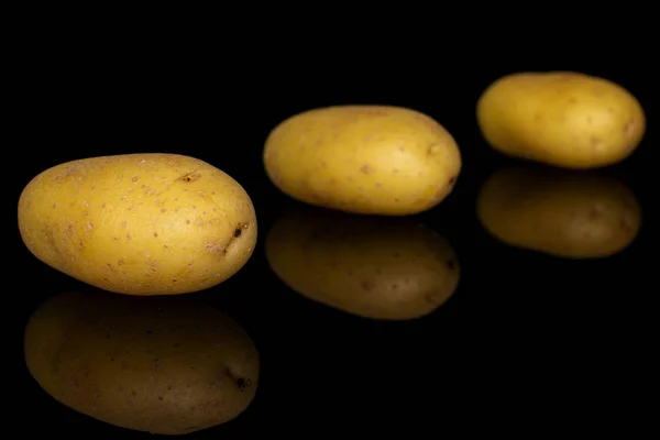 Желтый бледный картофель, изолированный на черном стекле — стоковое фото