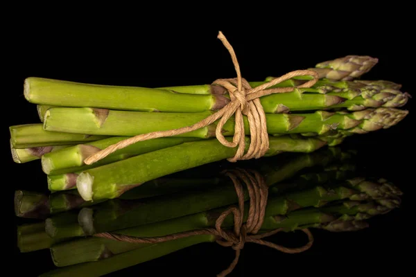 Gesunder grüner Spargel isoliert auf schwarzem Glas — Stockfoto