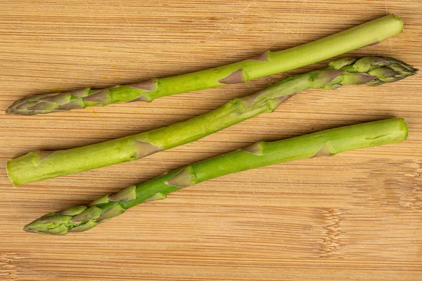 Healthy green asparagus on light wood — Stock Photo, Image