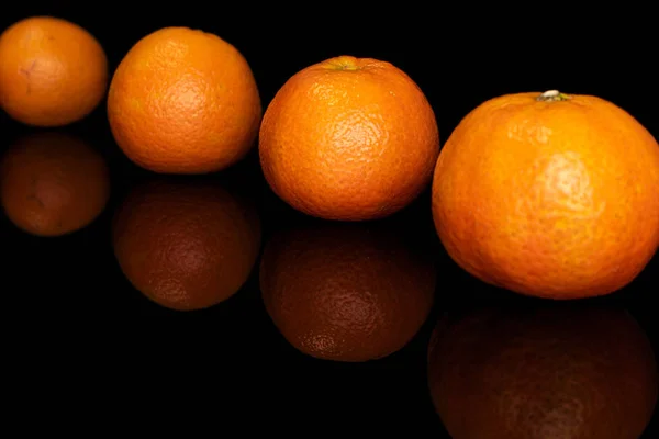 Frische orange Mandarine isoliert auf schwarzem Glas — Stockfoto