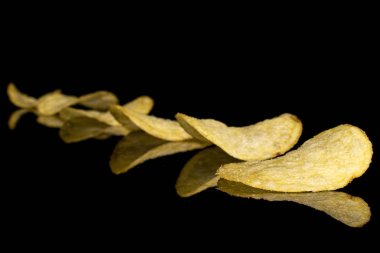 Siyah camda izole edilmiş çıtır patates cipsi.
