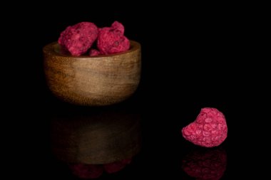 Kurutulmuş kırmızı ahududu siyah camda izole edilmiş.