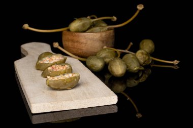 Siyah camda izole edilmiş yeşil turşulu kapari.