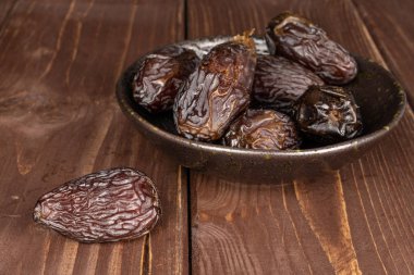 Kahverengi tahtada kurumuş hurma meyvesi.