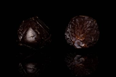 Kurumuş hurma meyvesi siyah camda izole edilmiş.