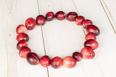 Gri ahşap üzerinde taze kırmızı kızılcık