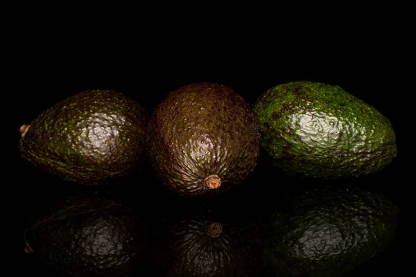 Νωπά πράσινα αβοκάντο απομονωμένα σε μαύρο γυαλί — Φωτογραφία Αρχείου