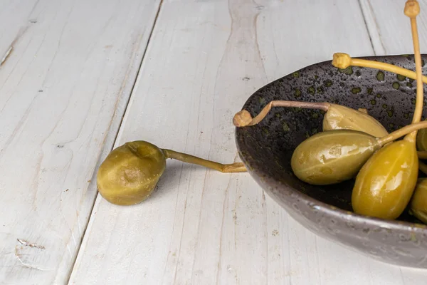 Alcaparra verde en escabeche sobre madera gris — Foto de Stock